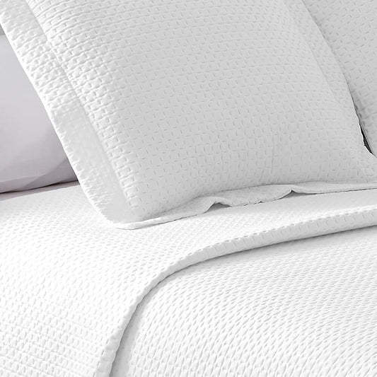 Colcha de retalhos geométrica com enchimento fino. Cor bege.