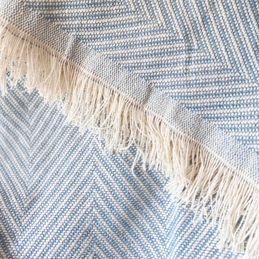 Colcha multiusos para sofá ou cama com franjas. Cor bege e cru.