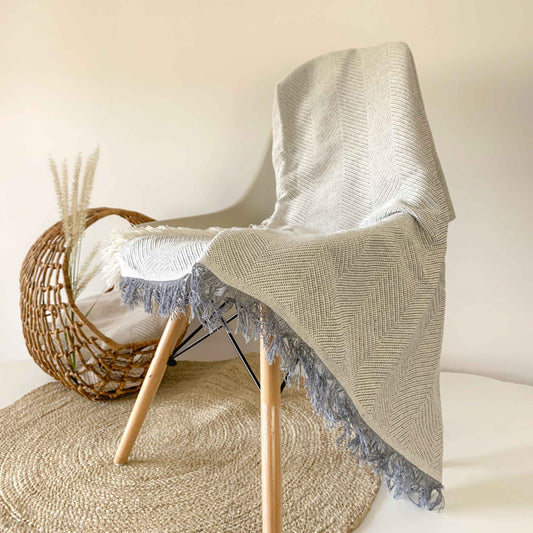 Colcha multiusos para sofá ou cama com franjas. Cor cinza pérola.