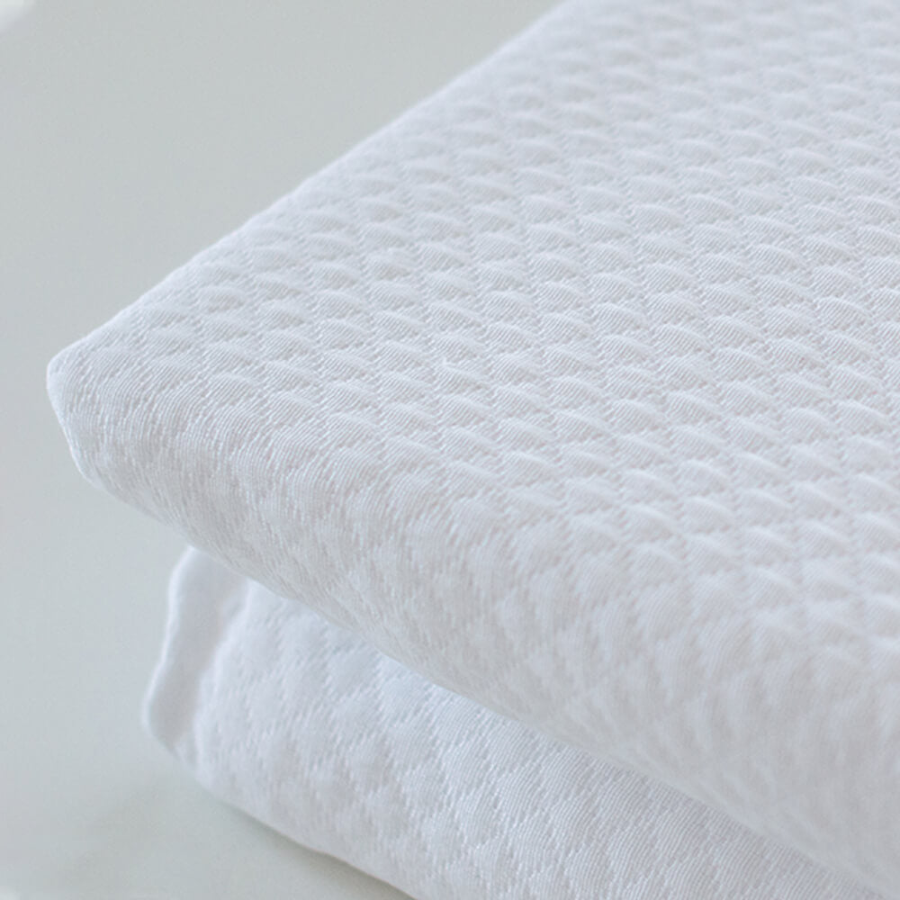 Colcha de retalhos geométrica com enchimento fino. Cor bege.