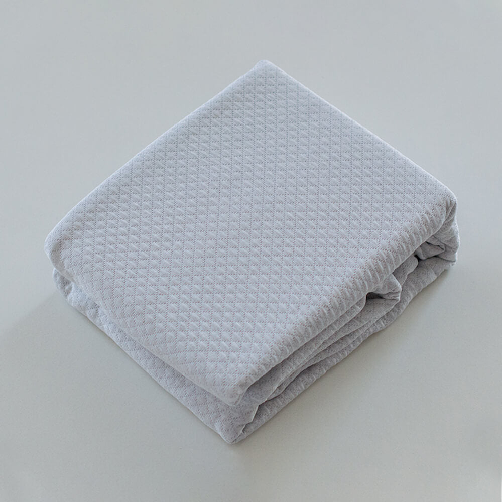 Colcha de retalhos geométrica com enchimento fino. Cor bege.