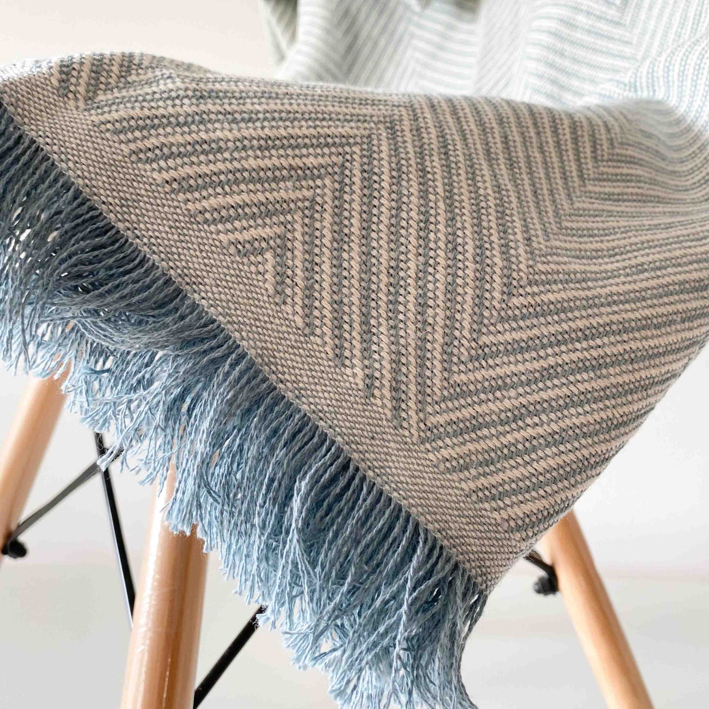 Colcha multiusos para sofá ou cama com franjas. Cor bege e cru.