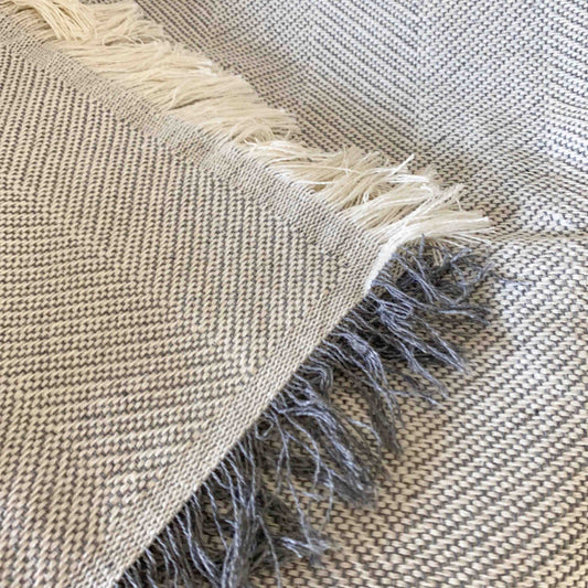 Colcha multiusos para sofá ou cama com franjas. Cor cinza pérola.