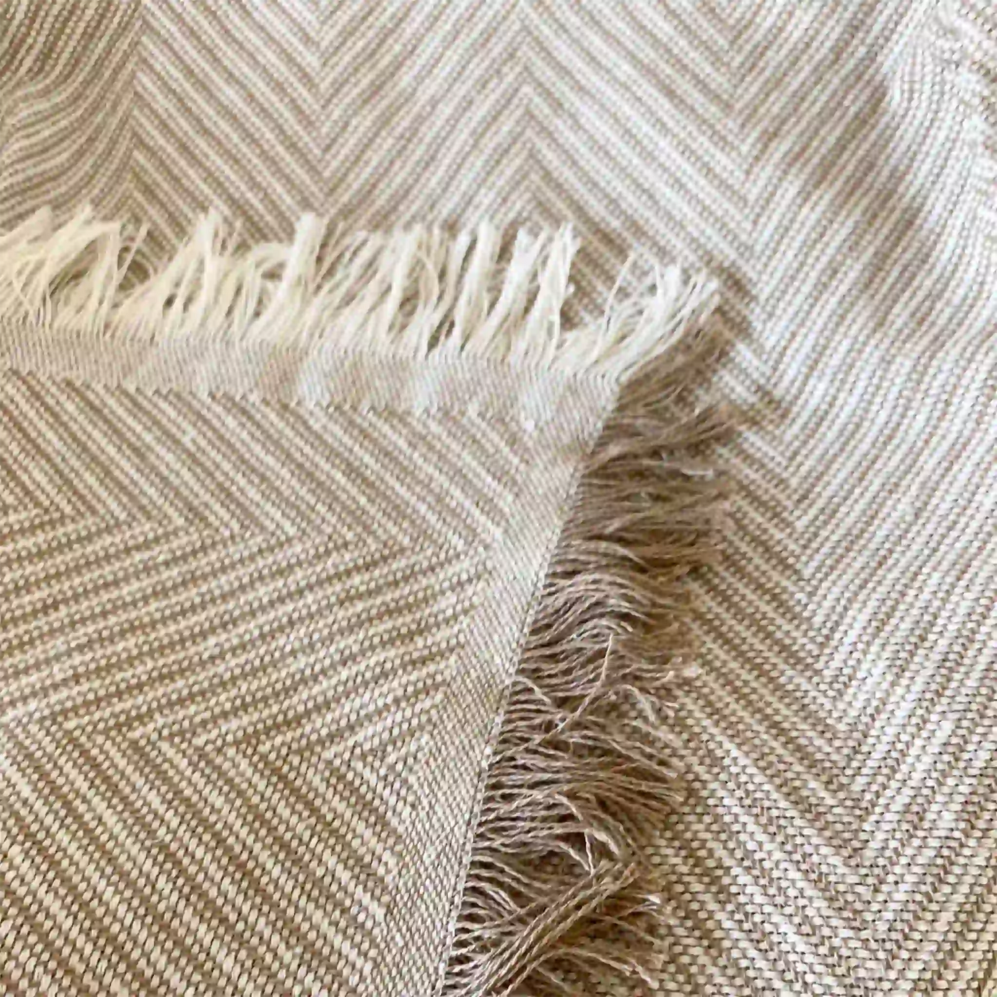 Detalle de la esquina de la colcha de verano mostrando el remate decorativo con flecos y el acabado de calidad del hilo de algodón en tono natural.