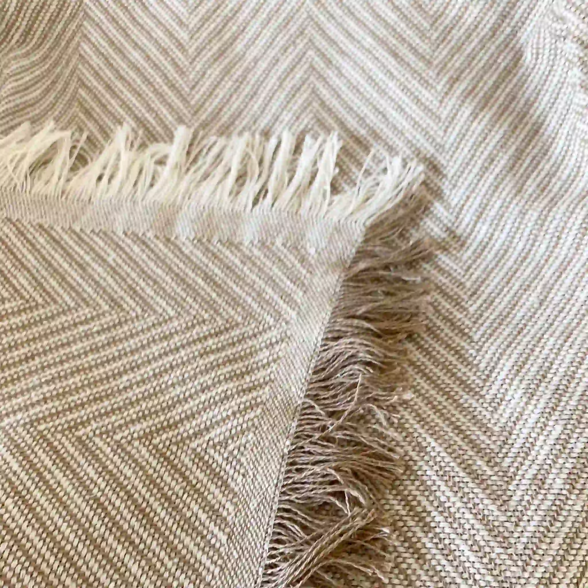 Detalle de la esquina de la colcha de verano mostrando el remate decorativo con flecos y el acabado de calidad del hilo de algodón en tono natural.